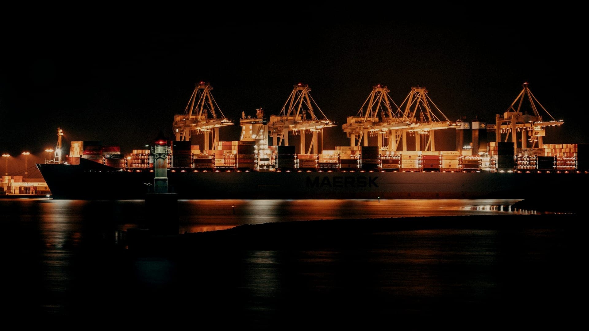 Container ship and port cranes at night